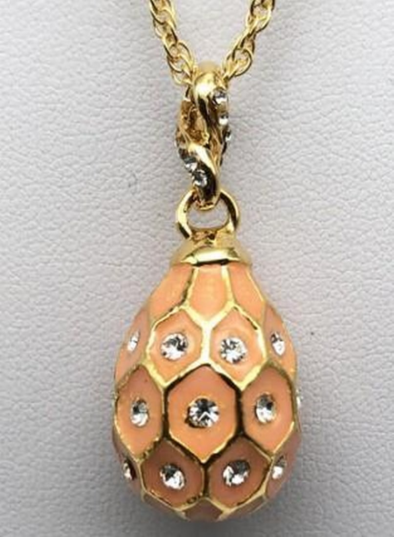 Coral Luxe Egg Pendant Necklace: Coral Luxe Egg Pendant Necklace Warm and refined, this coral egg pendant is accented with elegant gold detailing, creating a striking balance of color and shine. The rich coral enamel evokes a sense
