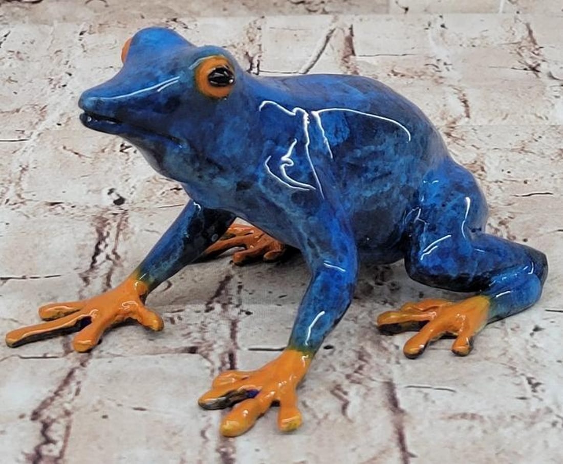 Vibrant Sentinel Bronze Poison Dart Frog Sculpture: Vibrant Sentinel Bronze Poison Dart Frog Sculpture This striking bronze sculpture captures the vivid allure of the Blue & Orange Poison Dart Tree Frog, rendered with lifelike detail and brilliant 