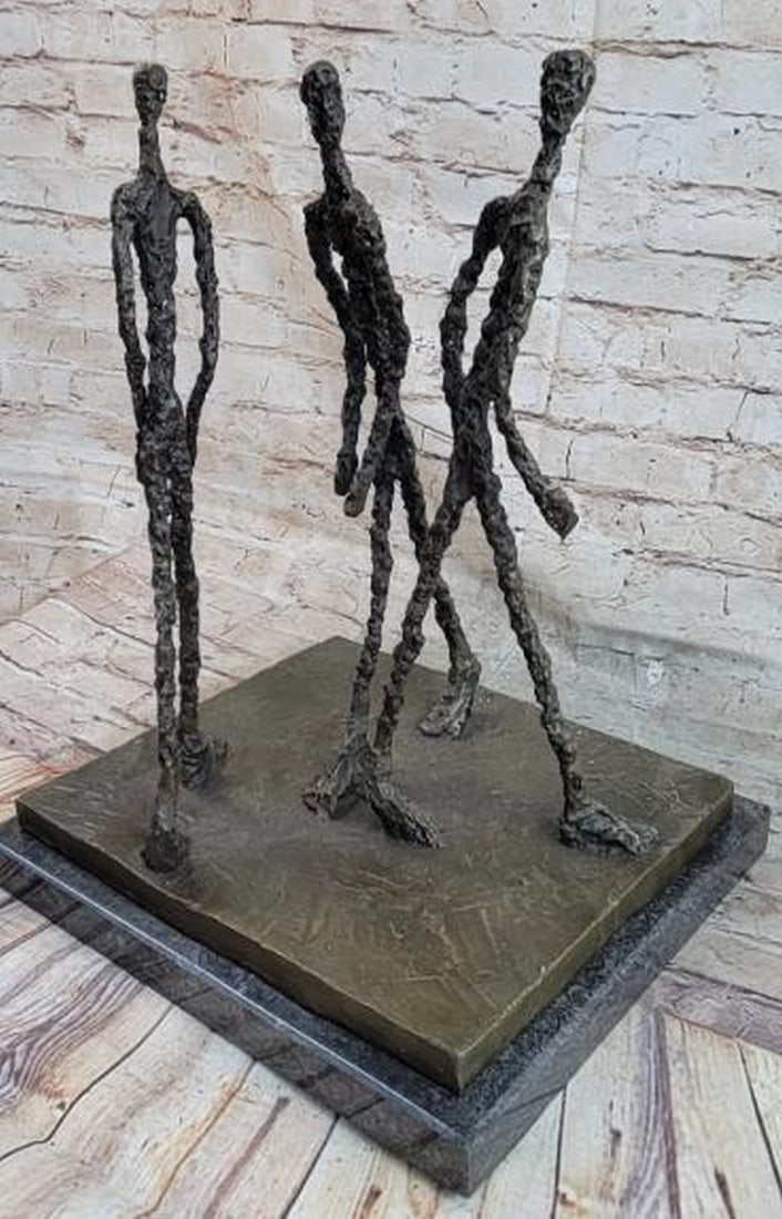 The Walkers: Reproduction Bronze Sculpture: The Walkers: Reproduction Bronze Sculpture This evocative bronze sculpture, bearing the signature of Alberto Giacometti, features three elongated male figures walking together in unison. Rendered in G