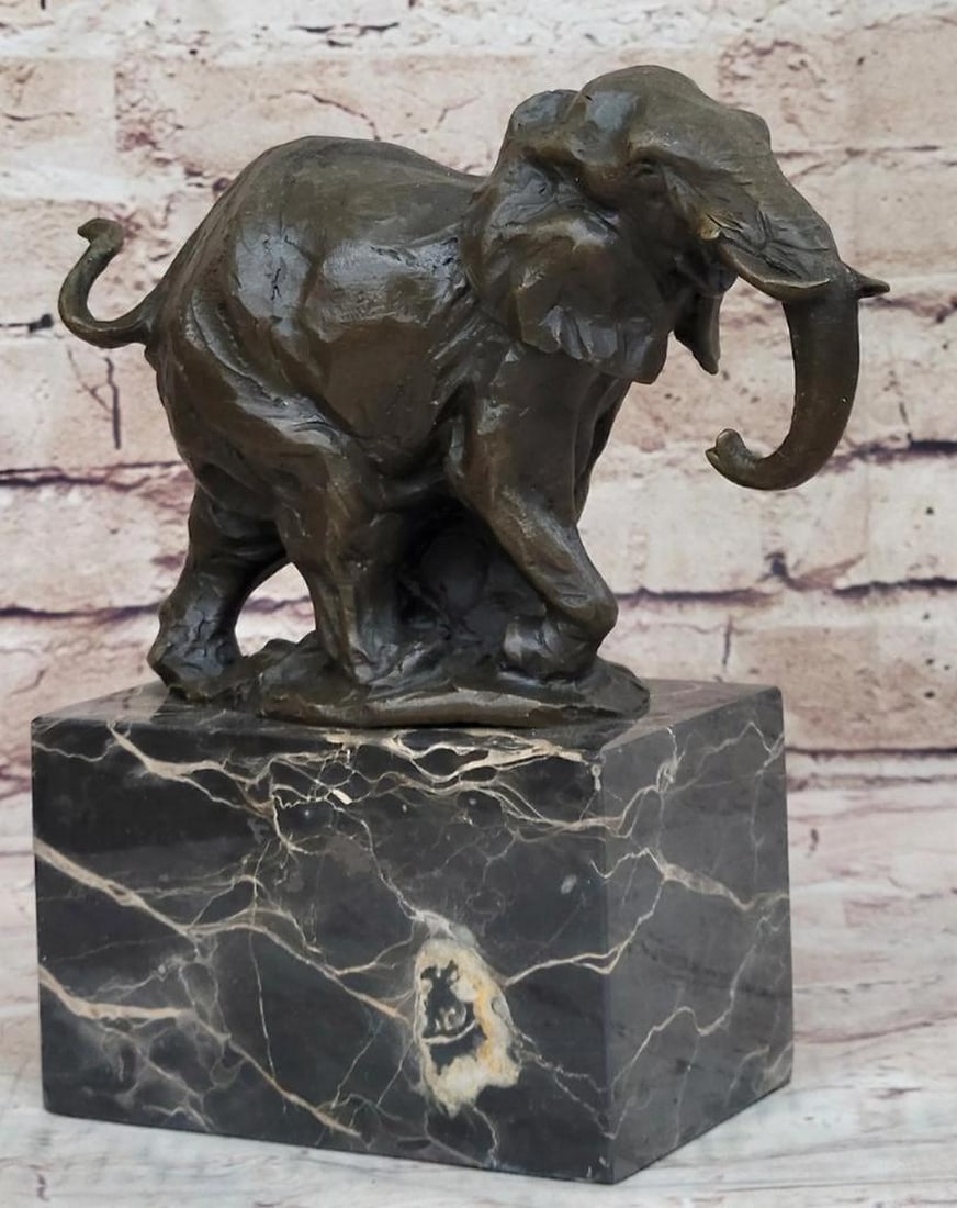 Noble Elephant Original Bronze Statue - 9" x 8": Noble Elephant Original Bronze Statue - 9" x 8" This original bronze statue depicts a noble elephant in mid-stride, with its trunk curled upwards and ears flared out, suggesting movement and v