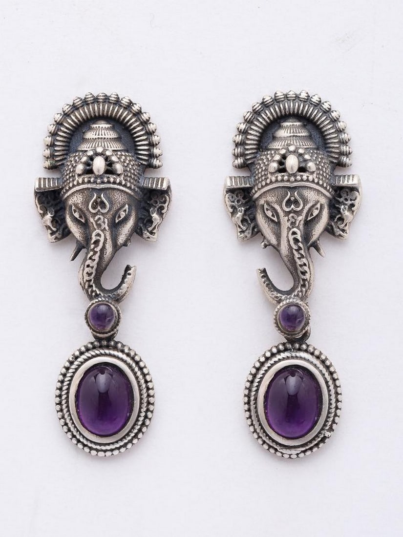 Lord Ganesha Oxidized Silver Earrings with Amethyst Drop: Lord Ganesha Oxidized Silver Earrings with Amethyst Drop These beautifully crafted oxidized sterling silver earrings feature a detailed depiction of Lord Ganesha, symbolizing wisdom and the removal of