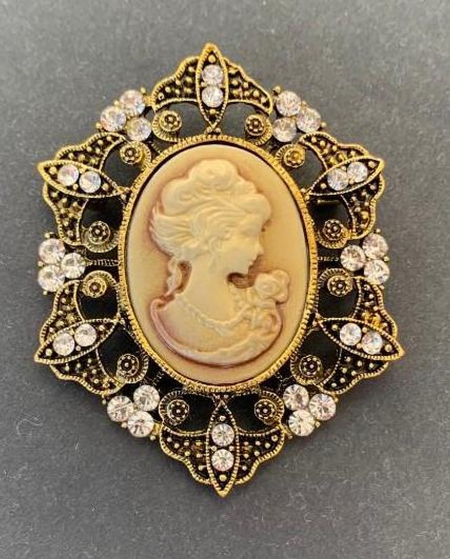 Victorian Cameo Brooch with Crystal-Embellished Frame: Victorian Cameo Brooch with Crystal-Embellished Frame This elegant brooch features a classic Victorian-style cameo of a woman at its center, framed by shimmering white crystals and intricate metal