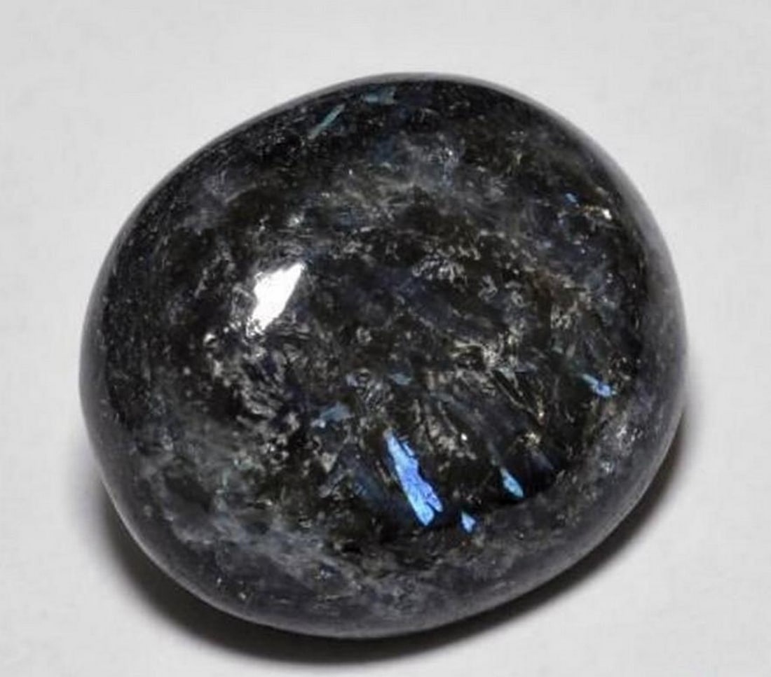 10.9ct Oval Cabochon Blue Sparkle Black Nuummite Gemstone: 10.9ct Oval Cabochon Blue Sparkle Black Nuummite Gemstone Type: Nuummite Weight: 10.98 ct 1 gem Size: 15.6 x 13.6 x 5.8 mm Exact Size: 15.60 x 13.59 x 5.81 mm Shape: Oval Cabochon Color: Black with Bl
