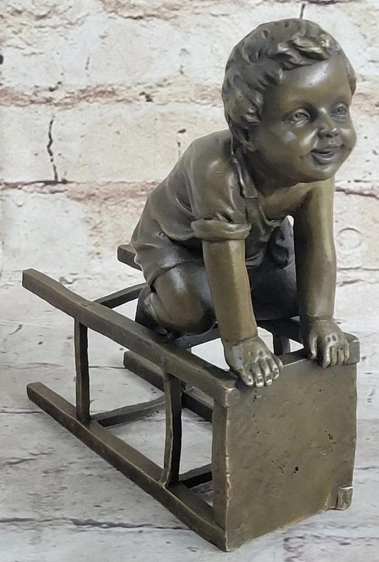 J. Clara Inspired Playful Boy with Stool Bronze Sculpture – 7" x 6": J. Clara Inspired Playful Boy with Stool Bronze Sculpture – 7" x 6" This bronze sculpture depicts a young boy seated on his knees beside an overturned stool, holding onto it with both hands.