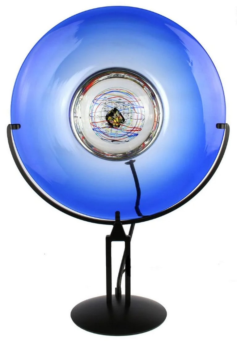 Murano Glass Sky Disc Table Lamp: Murano Glass Sky Disc Table Lamp This stunning disc table lamp is handcrafted using the submerged glass technique. The adjustable light on the backside allows for versatile illumination. Ideal for enh