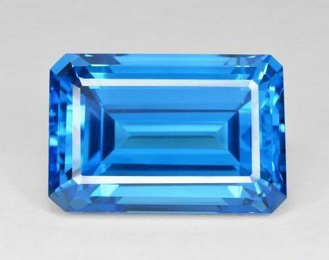61.6ct Octagon Step Cut Swiss Blue Topaz: 61.6ct Octagon Step Cut Swiss Blue Topaz Type: Topaz Weight:61.60 ct Size:25 X 18 mm Shape: Octagon Step Cut Color: Swiss Blue Clarity: IF Treatment: Irradi
