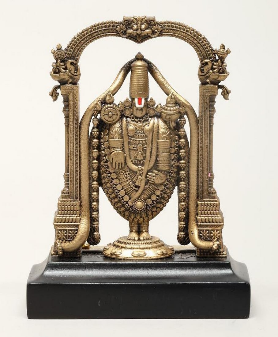 Standing Tirupati Balaji Mini Brass Statue with Kirtimukha Arch: Standing Tirupati Balaji Mini Brass Statue with Kirtimukha Arch This handcrafted brass statue depicts Tirupati Balaji, a revered incarnation of Lord Vishnu, standing beneath a Kirtimukha arch, a