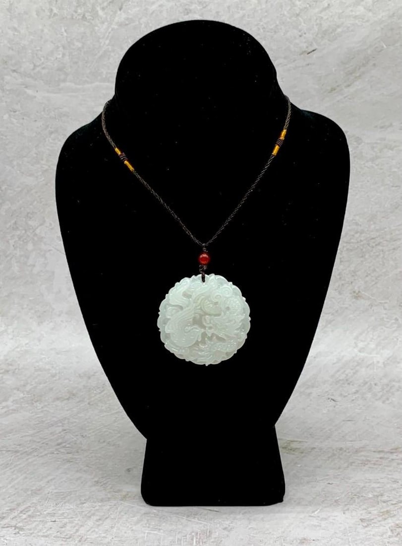 A CARVED WHITE JADE PEACOCK DRAGON MEDALLION (1 of 3)