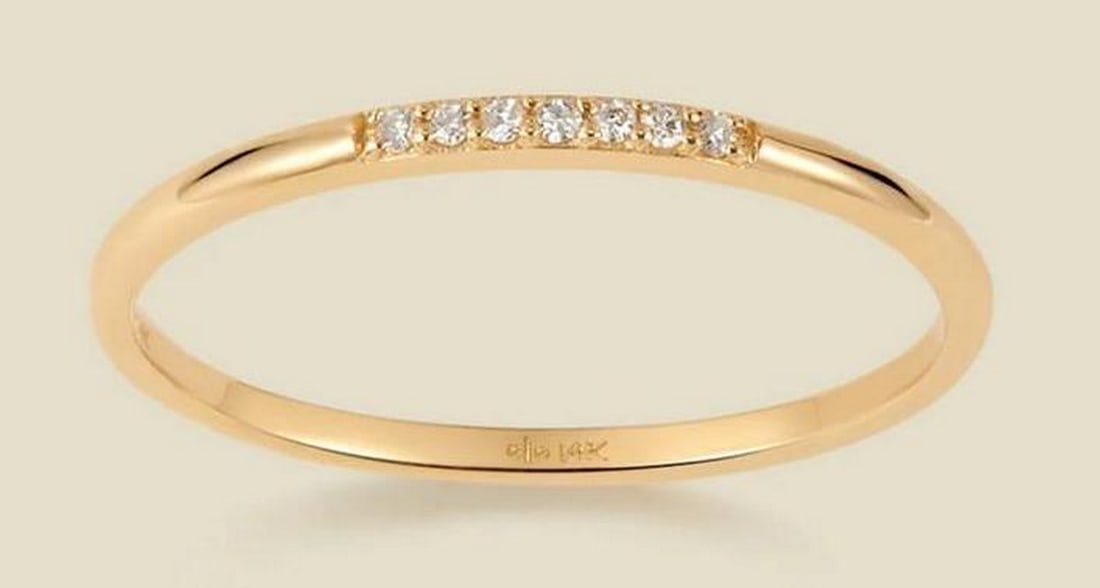 Celeste Diamond Band: Celeste Diamond Band Inspired by the brilliance of the night sky, this delicate 14k solid gold band features seven round-cut diamonds in a radiant line. Whether worn alone for a subtle shimmer or