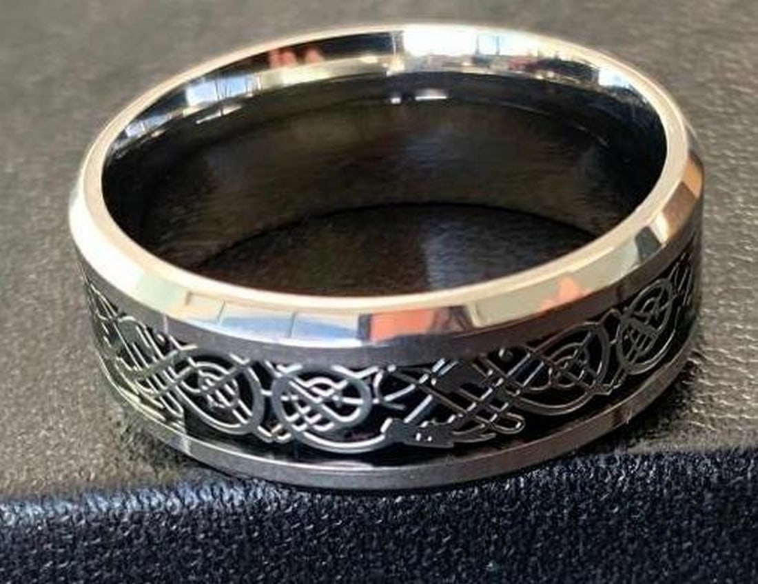 Intricately Carved Titanium Ring: Intricately Carved Titanium Ring Crafted from titanium, this ring features a carved central channel filled with intricate detailing. The recessed design is accented with a deep black background,