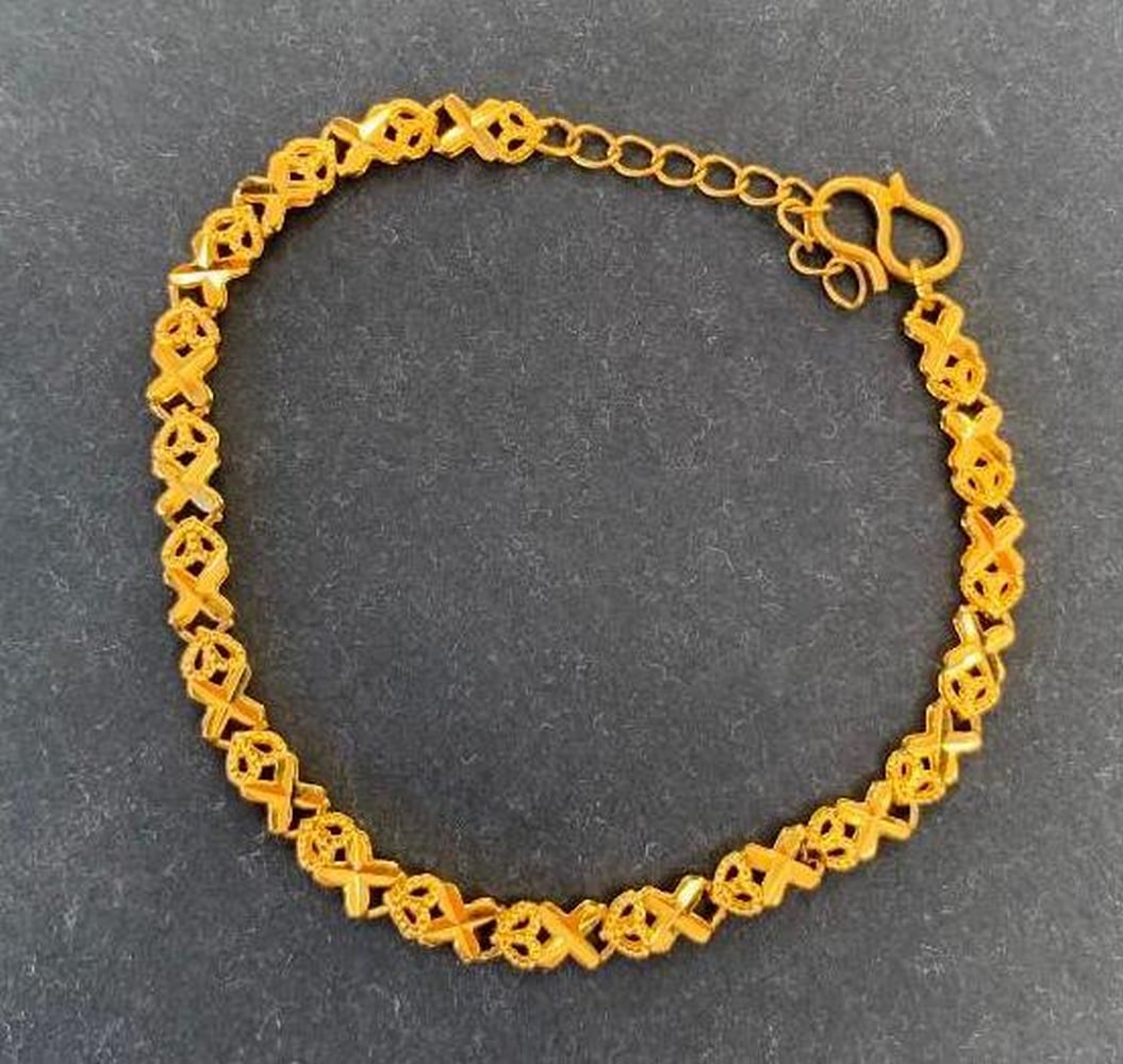 Gold Tone X and Heart Link Bracelet: Gold Tone X and Heart Link Bracelet A beautifully designed gold-toned bracelet showcasing a repeating pattern of X’s and hearts, symbolizing love and connection. The linked design offers a smooth,
