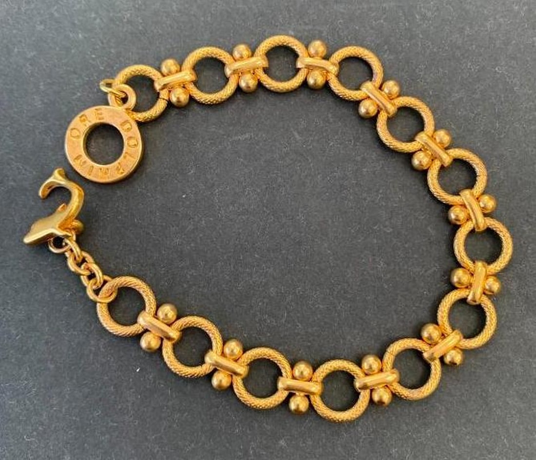 Gold Circle Link Bracelet: Gold Circle Link Bracelet This gold-toned circle link bracelet combines timeless style with unique charm. The clasp is engraved with Dolphin Ore, adding a distinctive, signature touch that sets this