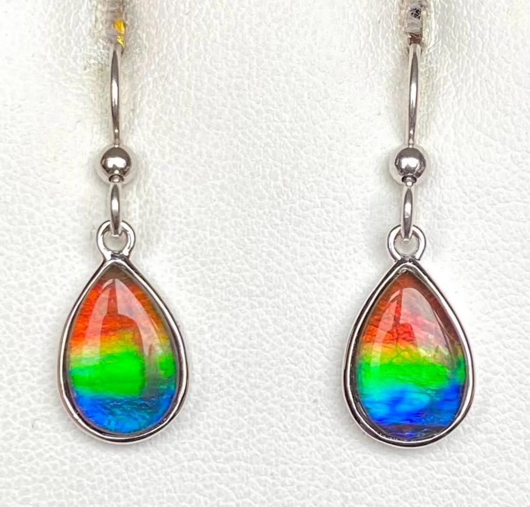 Multi-colour Teardrop Ammolite Earrings: Multi-colour Teardrop Ammolite Earrings These Ammolite earrings feature a graceful teardrop shape with tricolor gemstones measuring 12mm x 8mm as low-dome quartz-capped triplets. Set in sterling