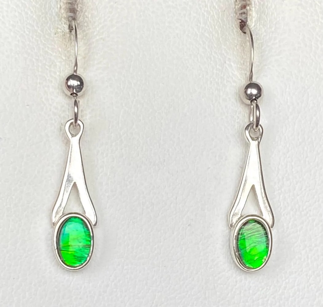 Petite Green Ammolite Earrings: Petite Green Ammolite Earrings This set of Ammolite earrings showcases petite green gemstones that transform to blue at extreme angles. The 6mm x 4mm quartz-capped triplets are beautifully set in 925