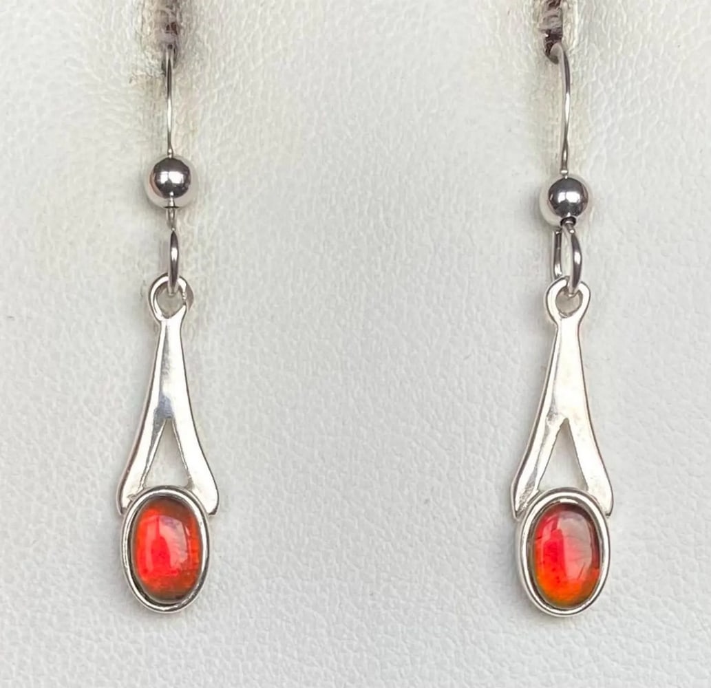 Petite Red Ammolite Earrings: Petite Red Ammolite Earrings This set of Ammolite earrings features petite red gemstones that shift to green at extreme angles. The 6mm x 4mm quartz-capped triplets are set in 925 sterling silver for