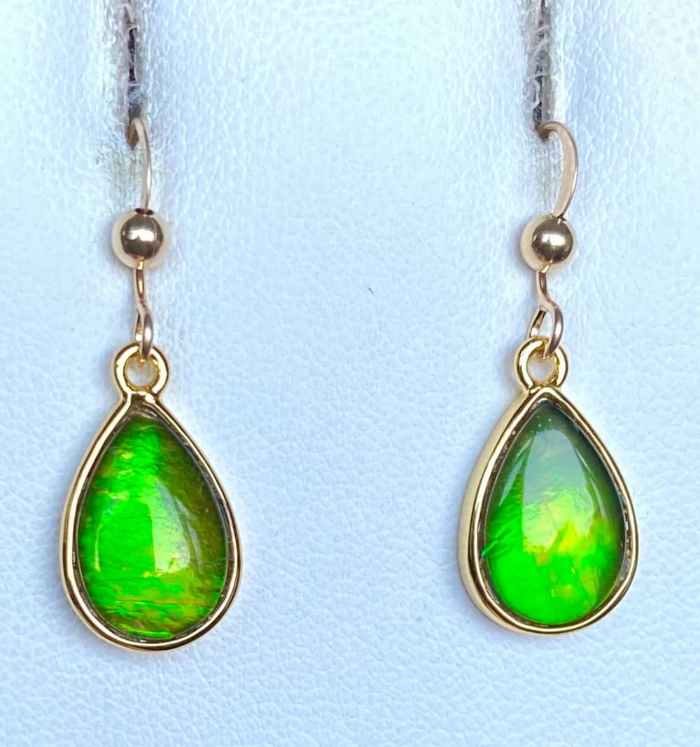 Teardrop Green Ammolite Earrings: Teardrop Green Ammolite Earrings These teardrop-shaped Ammolite earrings feature 12mm x 8mm low-dome quartz-capped triplets. Set in gold-plated (vermeil) sterling silver, they are paired with durable
