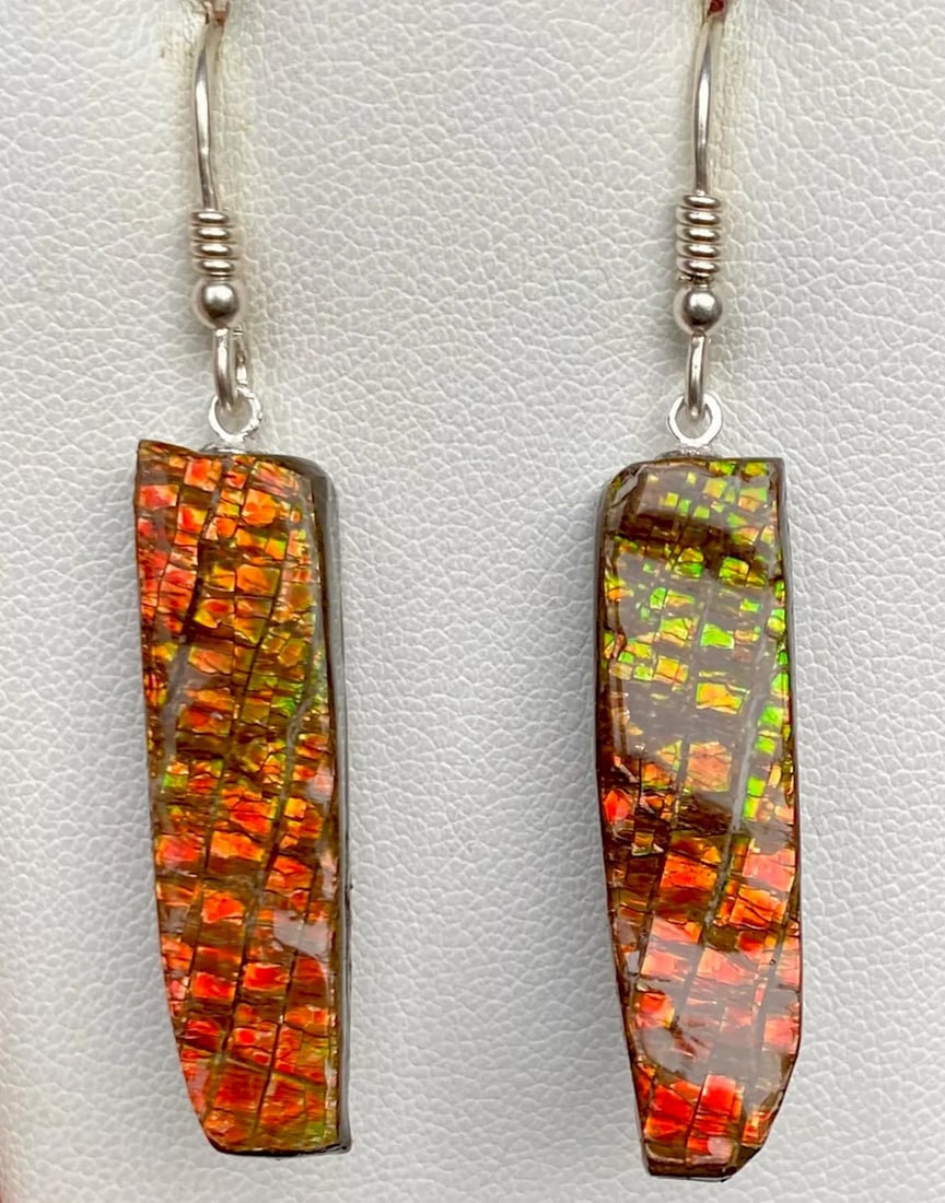 Dragon Skin Ammolite Earrings: Dragon Skin Ammolite Earrings This is a pair of earthy Ammolite earrings. The gemstones average 31mm x 8mm and have a thin coating They color change to green at extreme angles. They hang from sterling