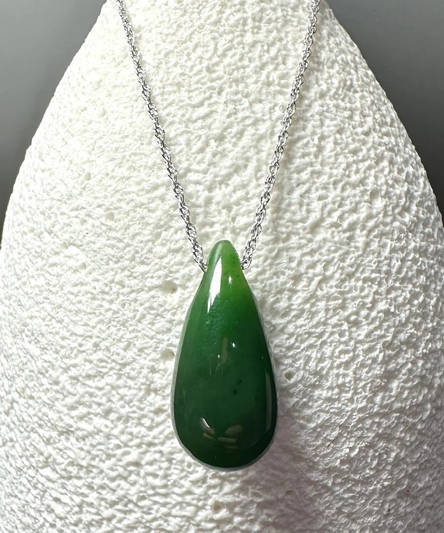 Canadian Nephrite Jade Tear Drop Pendant: Canadian Nephrite Jade Tear Drop Pendant A sleek, artfully carved piece crafted from authentic Canadian Nephrite Jade. Featuring a graceful teardrop shape measuring approximately 13?mm by 28?mm and fi