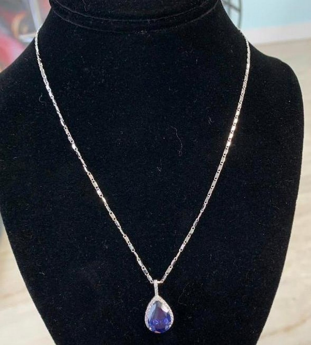 Sterling Silver Necklace with Blue Stone Pendant: Sterling Silver Necklace with Blue Stone Pendant A stunning combination of sparkle and sophistication. This sterling silver necklace features a pendant with a vibrant blue stone at its center, surroun