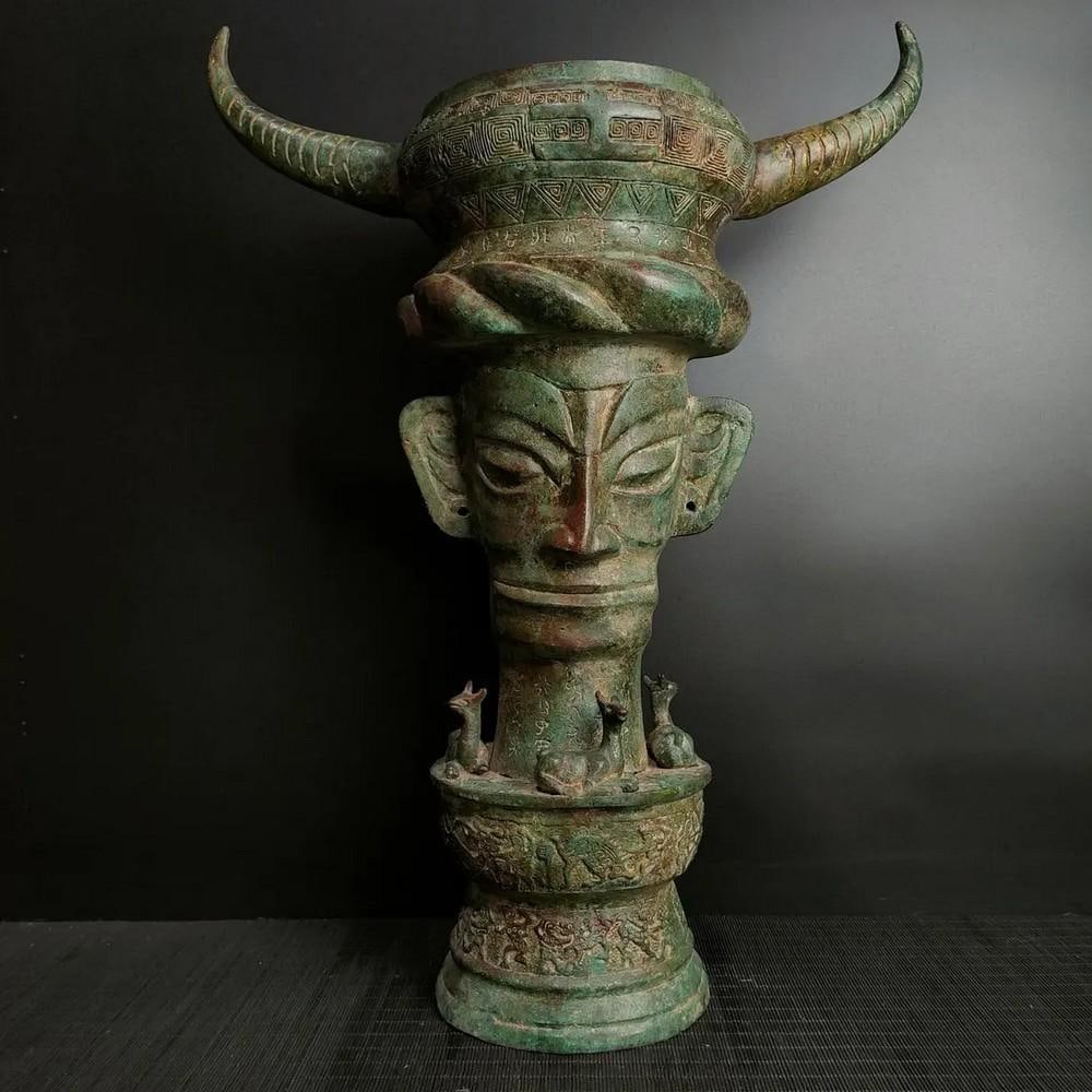 Antique Chinese Bronze Sanxingdui Tiangu Statue Ornament: Antique Chinese Bronze Sanxingdui Tiangu Statue Ornament This rare handcrafted bronze statue represents the ancient Sanxingdui Tiangu, a symbol of cultural heritage and divine power. The intricate