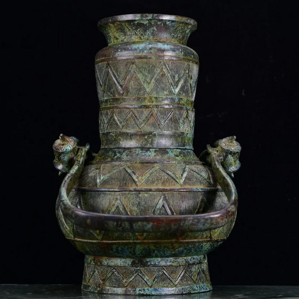 Antique Chinese Bronze Handled Pot Ornament: Antique Chinese Bronze Handled Pot Ornament This rare handcrafted bronze pot features gracefully designed handles and intricate detailing, showcasing the elegance of traditional Chinese craftsmanship.
