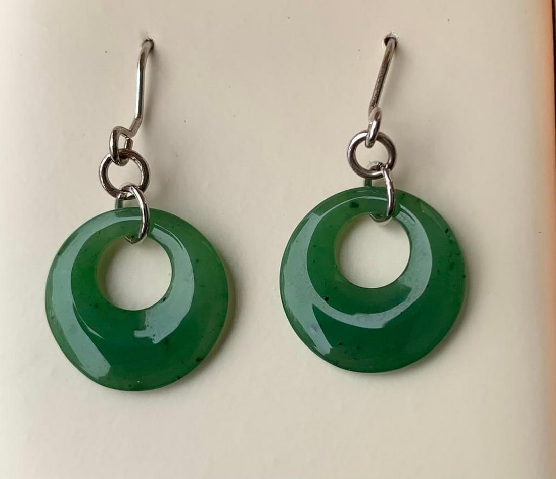 Dangling Green Jade Hoop Earrings: Dangling Green Jade Hoop Earrings Elegant and eye-catching, these green jade earrings feature delicately carved hoops that sway gently with movement. The natural jade is rich in color and smoothly