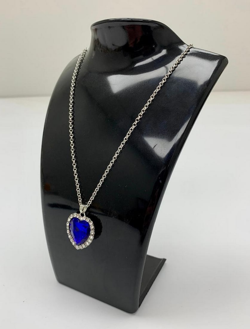 Silver-Tone Necklace with Blue Heart Pendant: Silver-Tone Necklace with Blue Heart Pendant This dazzling silver-tone necklace features a chain adorned with sparkling gemstones along its entire length, leading to a striking blue heart-shaped