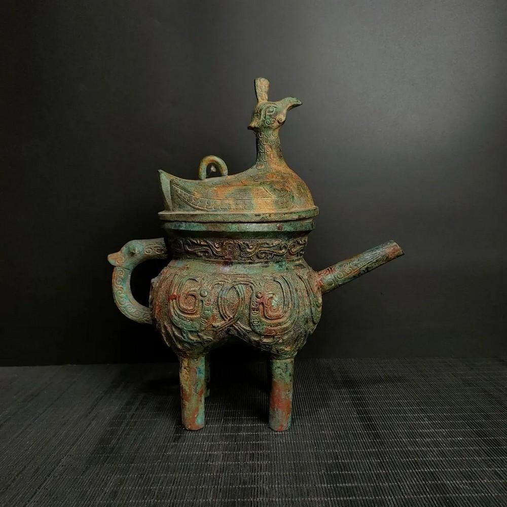 Antique Chinese Standing Bird Bronze Rice Pot: Antique Chinese Standing Bird Bronze Rice Pot This antique Chinese bronze rice pot features a unique standing bird design, symbolizing harmony and prosperity. The intricate detailing of the bird and t