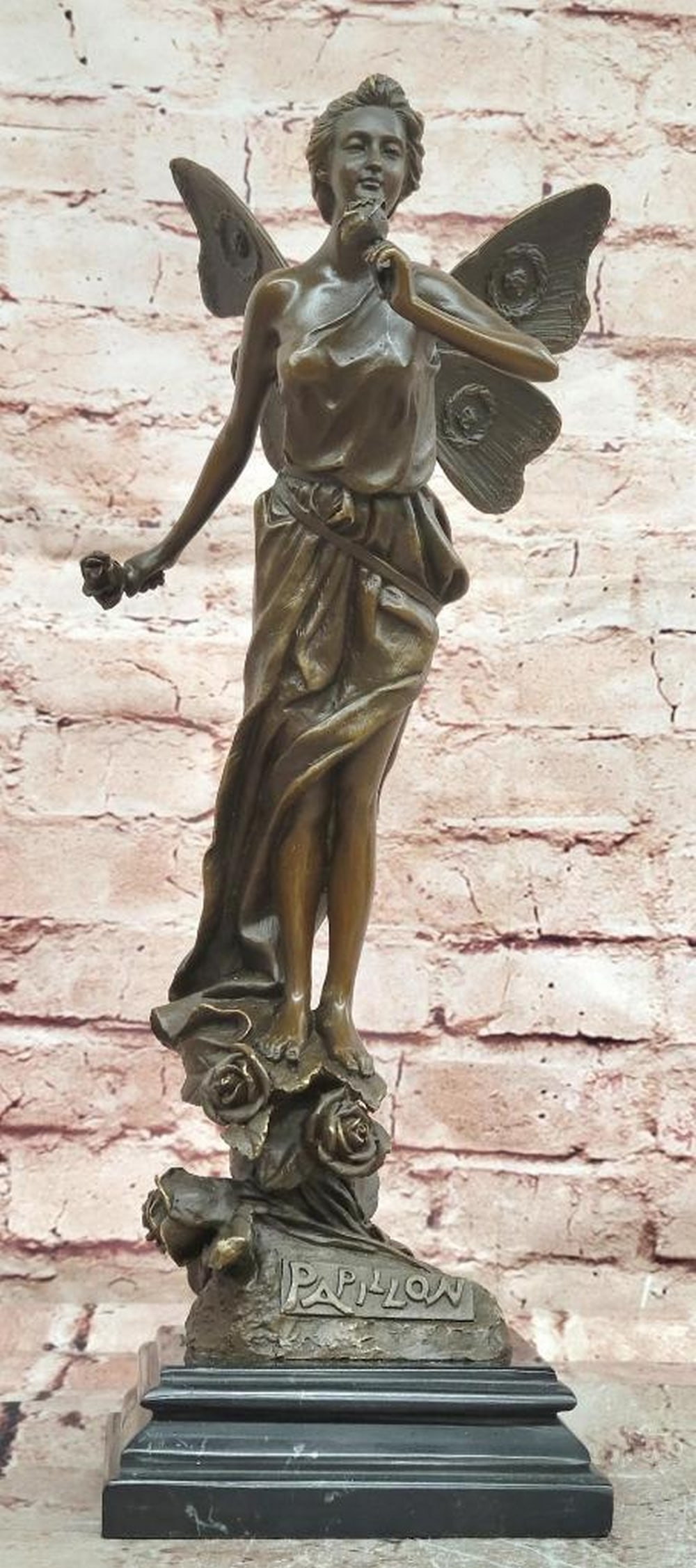 Papillion Fairy with Flower Bronze Sculpture on Marble Base – 15" x 5": Papillion Fairy with Flower Bronze Sculpture on Marble Base – 15" x 5" This bronze sculpture depicts a fairy holding a flower, rendered with delicate proportions, flowing lines, and an expre