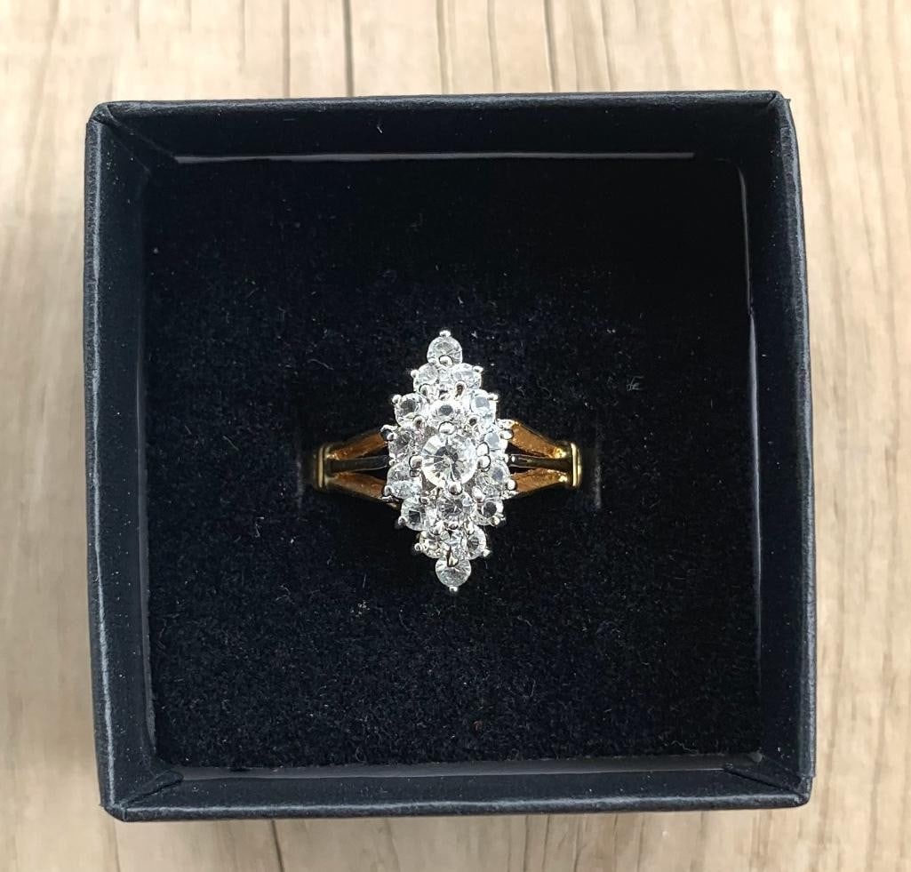 Royal Cluster Moissanite Ring: Royal Cluster Moissanite Ring Sophisticated round-cut moissanite cluster ring set in rich yellow gold, elegantly presented in a black velvet box. The center moissanite is surrounded by a dazzling halo