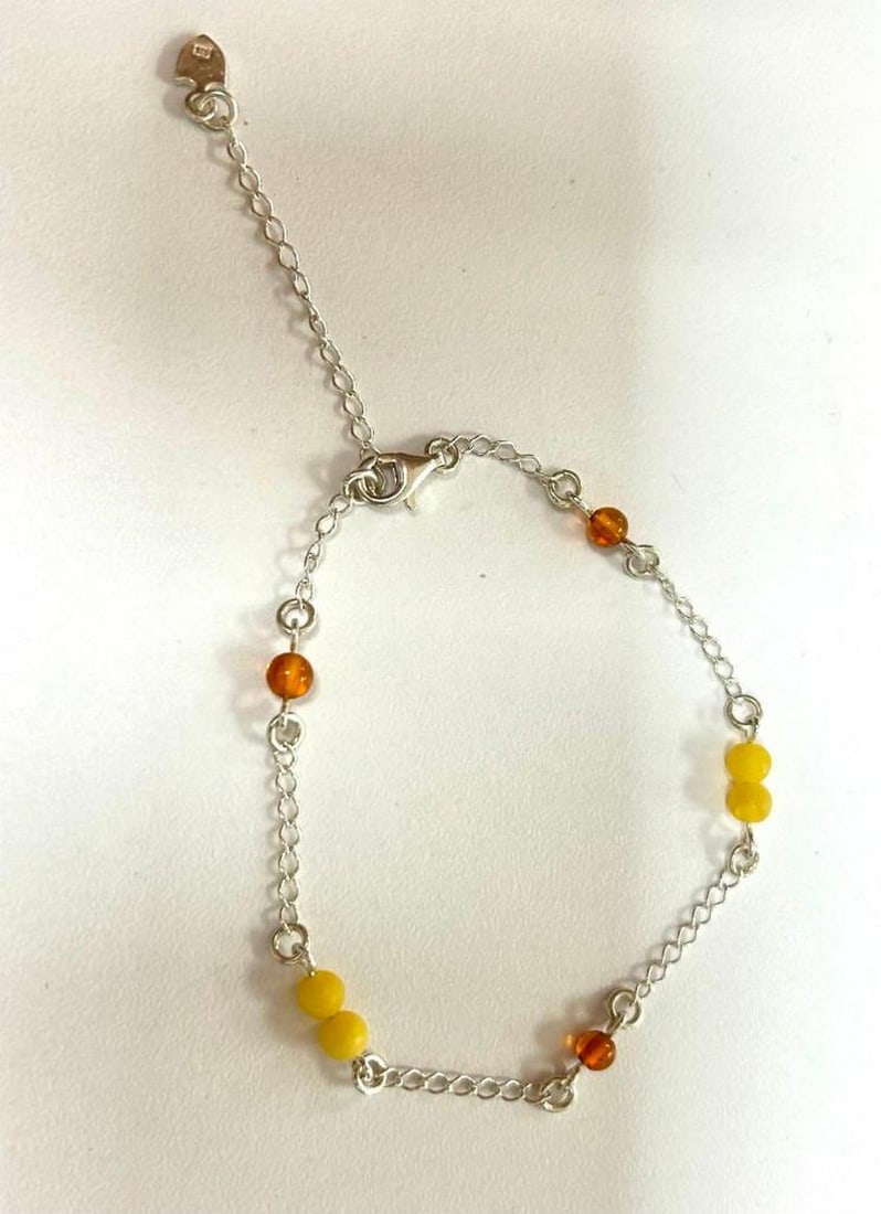 Harmony Spin Two-Hue Amber Sterling Silver Bracelet: Harmony Spin Two-Hue Amber Sterling Silver Bracelet This bracelet features a captivating design, showcasing a single brown amber ball followed by two yellow amber balls, creating a harmonious rotation