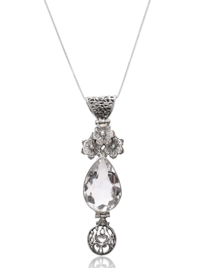 Petal Glow Crystal Charm`: Petal Glow Crystal Charm This sterling silver pendant showcases intricate floral accents and a flawless teardrop-shaped crystal. Blending elegance with modern sophistication, it complements any