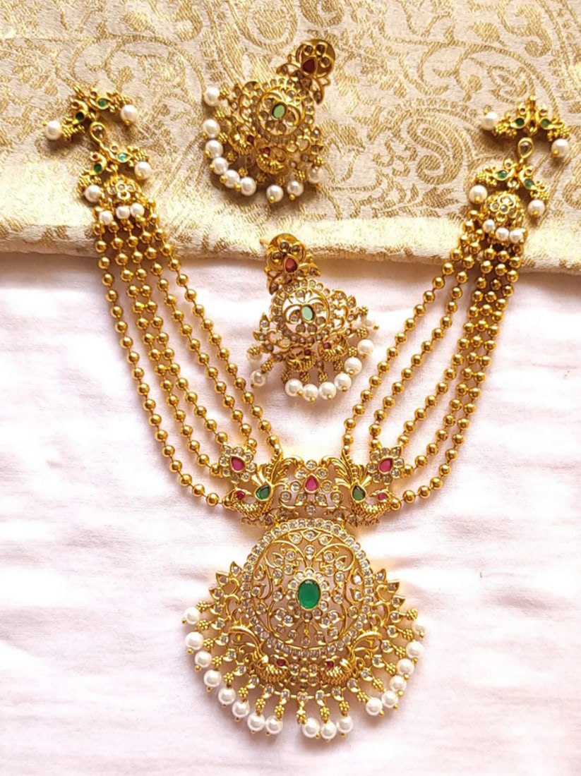 Golden Bloom Stonework Jewelry: Golden Bloom Stonework Jewelry Unlocking a queen’s treasure, this designer necklace set emerges as its finest jewel. Adorned with traditional motifs like foliage, parrots, and meticulously set