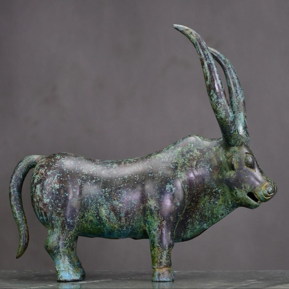 Handcrafted Chinese Bronze Ox Statue: Handcrafted Chinese Bronze Ox Statue This elegant bronze ox statue is a stunning example of traditional Chinese craftsmanship. Entirely handmade, the sculpture showcases intricate detailing and a rich