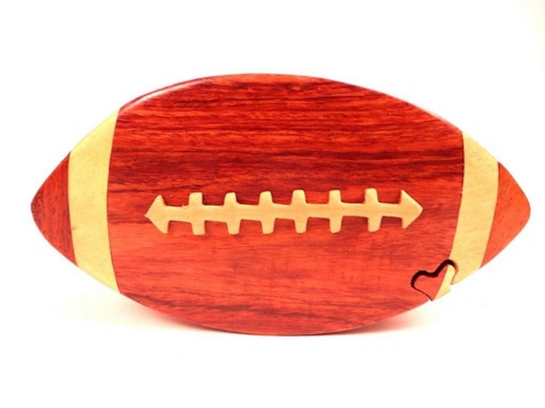 Mahogany Football Keepsake Box: Mahogany Football Keepsake Box This keepsake box is hand-carved from mahogany wood and features a football design on the exterior, with a red velvet-lined interior for storing small items. The box