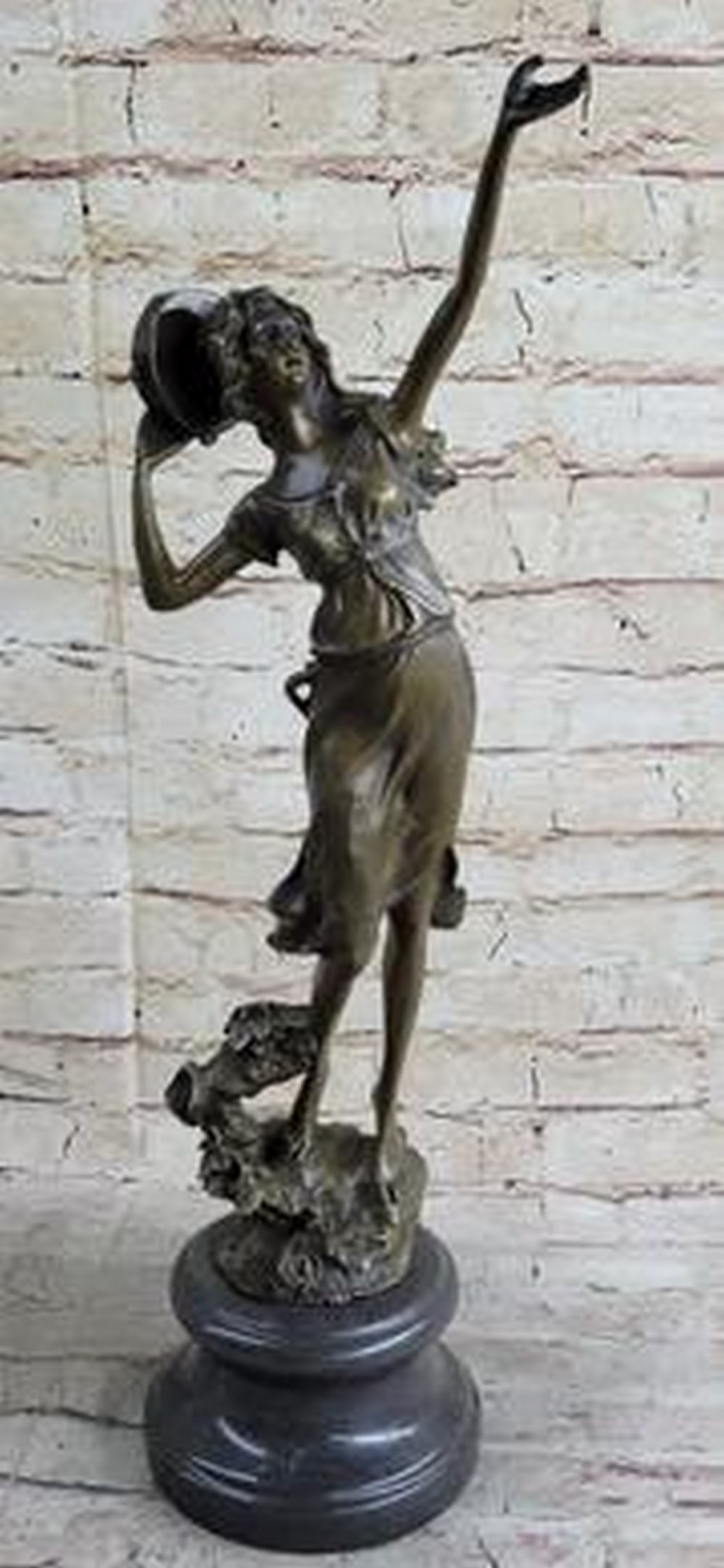 Moreau Reproduction Tambourine Dancer Bronze Sculpture: Tambourine Dancer Bronze Sculpture Beneath the open sky, the young woman gazes upwards, summoning the winds as she delicately taps her tambourine against her head. Her flowing dress and long hair sway