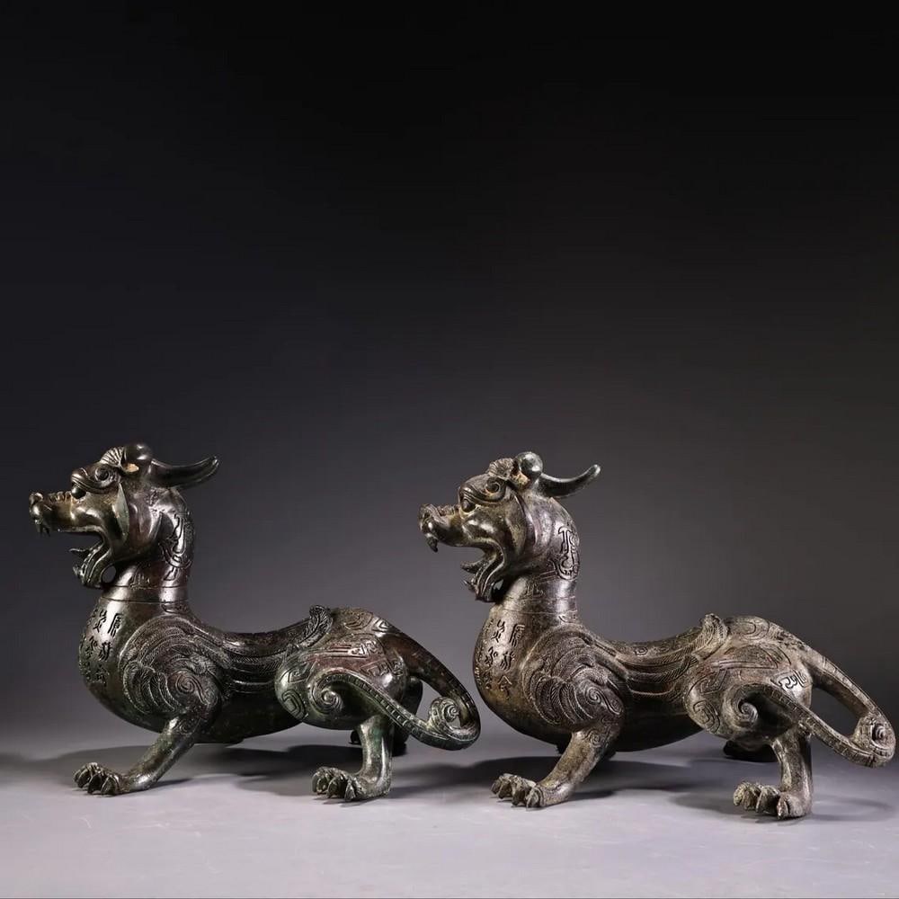 Pair of Antique Bronze Inscribed Animal Statues: Pair of Antique Bronze Inscribed Animal Statues This rare Chinese antique features a hand-crafted pair of bronze animals with intricate inscriptions, showcasing exquisite artistry and attention to det