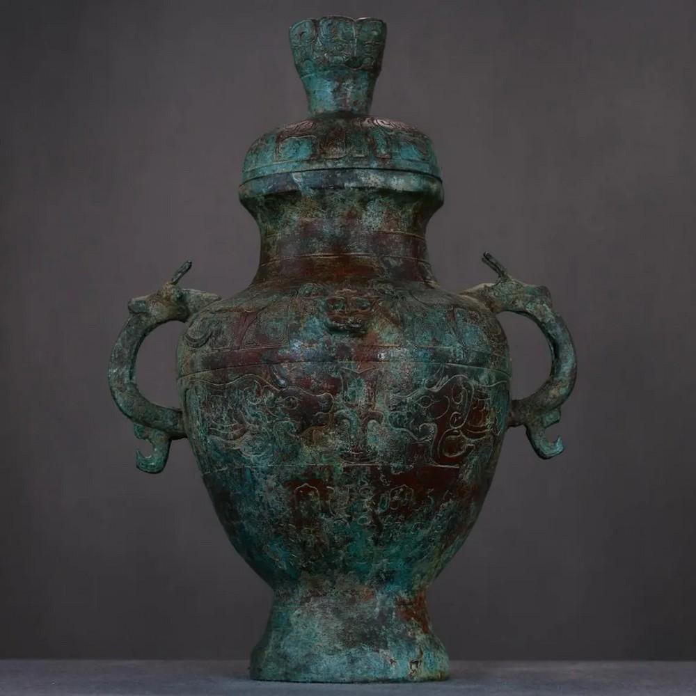 Antique Chinese Bronze Dragon Ear Pot Statue: Antique Chinese Bronze Dragon Ear Pot Statue This rare handmade bronze pot features intricately designed dragon-shaped handles, symbolizing power, strength, and protection in Chinese culture. The eleg