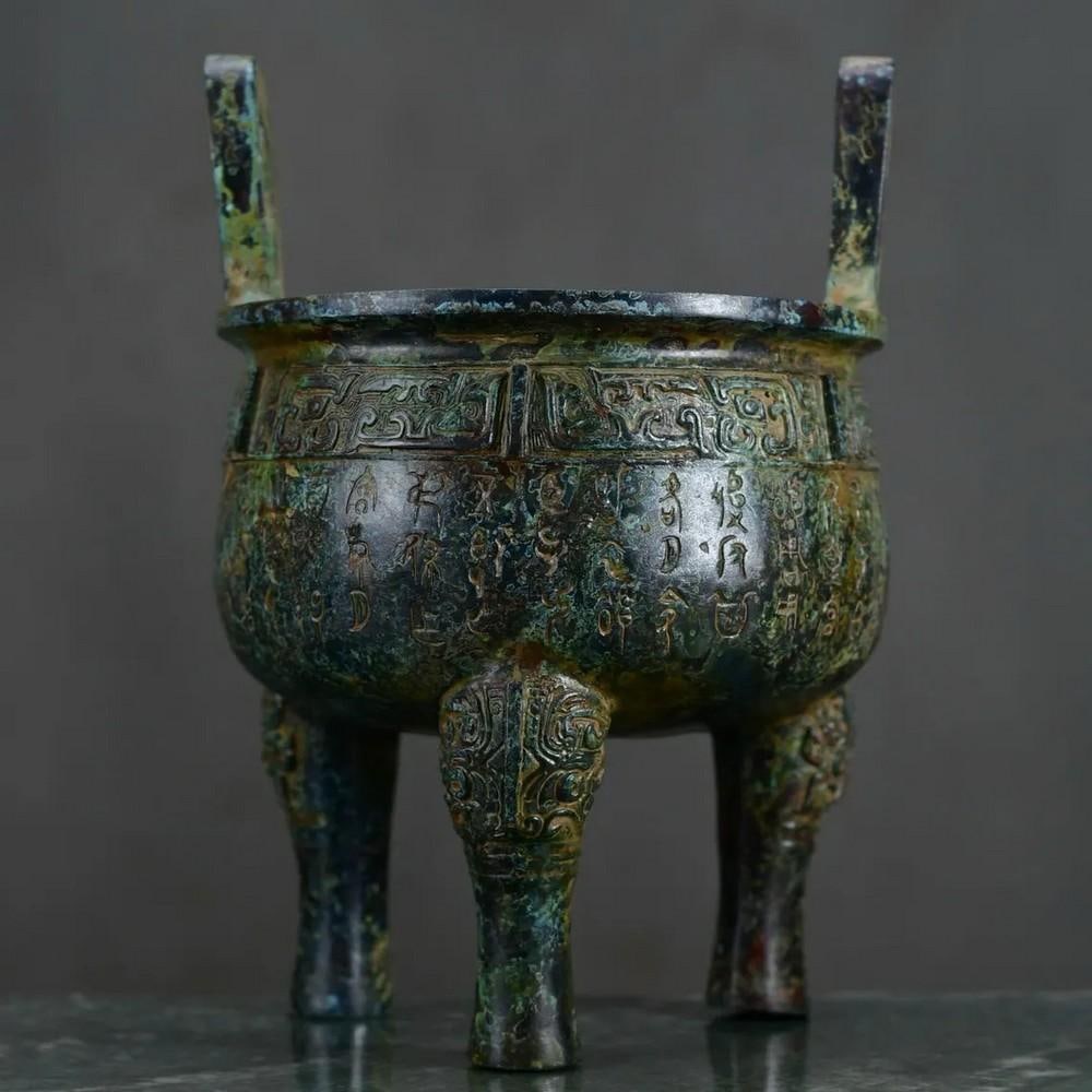 Antique Chinese Inscribed Tri-pod Ornament: Antique Chinese Inscribed Tri-pod Ornament This antique Chinese bronze tripod ornament features intricate inscriptions that reflect the cultural and historical significance of ancient China. The three