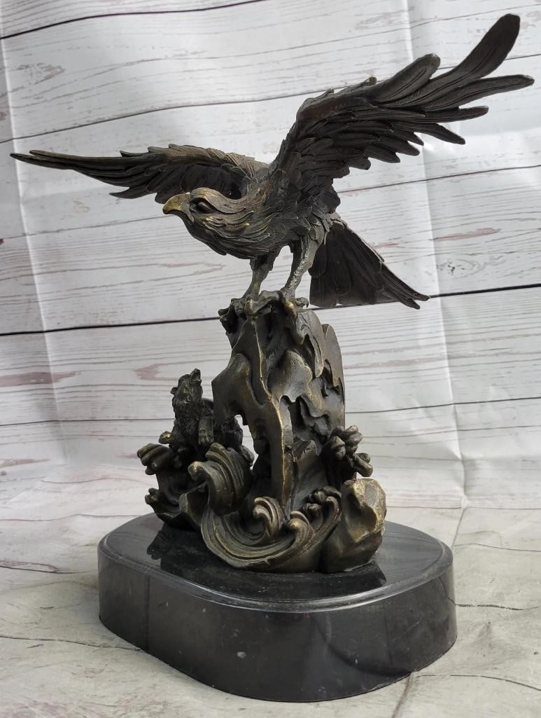 Original Eagle Landing on Waves Bronze Sculpture - 13'' x 13'': Original Eagle Landing on Waves Bronze Sculpture - 13x34 x 13x34 This bronze sculpture depicts a bird with its wings open, standing on a fluid-like bronze plinth. The bird appears to be absorbing its