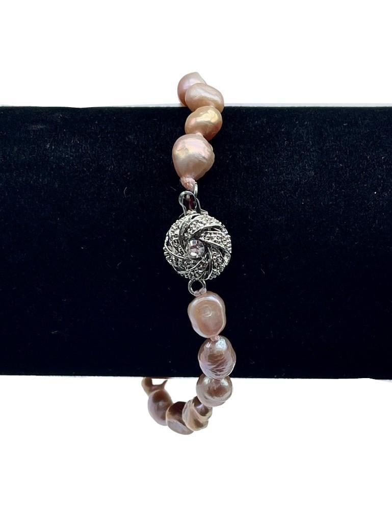 Coral Blush Pearl Bracelet: Coral Blush Pearl Bracelet This elegant 8-inch bracelet features lustrous coral blush pearls strung together for a timeless and feminine look. Its soft, warm hues make it a versatile accessory that