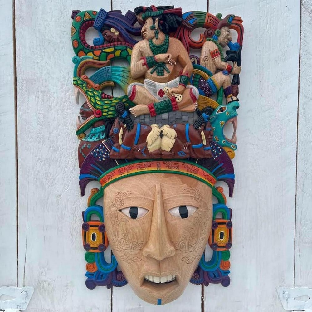 King Pakal Carrier Hand-Carved Cedar Mask: King Pakal Carrier Hand-Carved Cedar Mask This hand-carved wooden mask depicts King Pakal in a carrier-style design inspired by Mayan traditions and pre-Hispanic art. The composition features detailed
