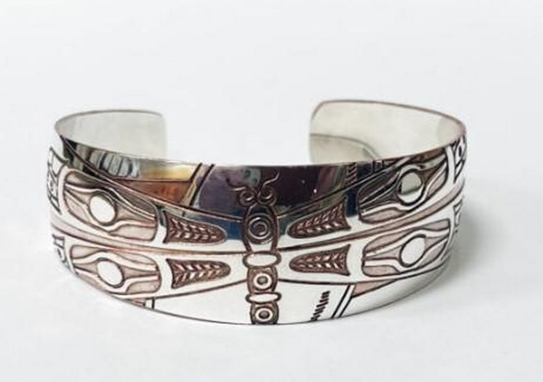 Wings of Twilight Bangle: Wings of Twilight Bangle This dragonfly bangle combines the warmth of copper with the elegance of sterling silver, creating a striking balance of nature and artistry. The delicate dragonfly motif is