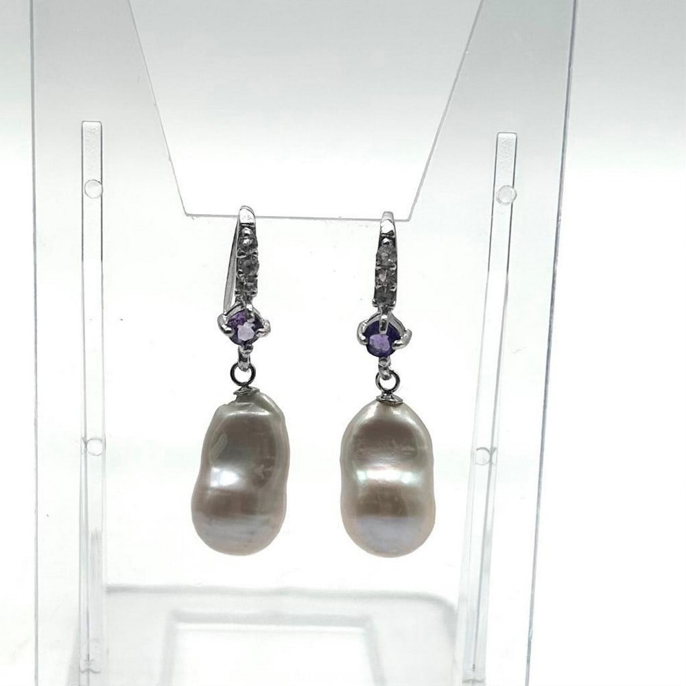 White Pearl And Amethyst Stone Earring: White Pearl And Amethyst Stone Earring These earrings are an exquisite and elegant accessory that combines the beauty of three gemstones in a stunning design; Pearls, Amethyst, and Cubic Zirconia. The