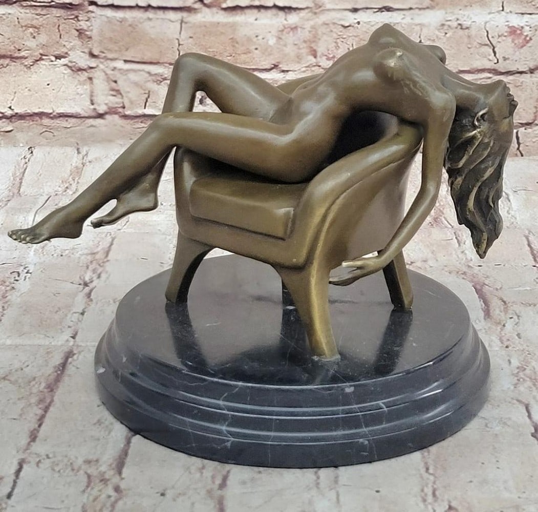 Side-Saddled Sensuality -Bronze Nude Sculpture by Mavchi - 9'' x 10'': Side-Saddled Sensuality -Bronze Nude Sculpture by Mavchi - 9" x 10" This captivating bronze sculpture by Mavchi portrays a nude woman seated side-saddled on a sofa, her flowing hair and confid
