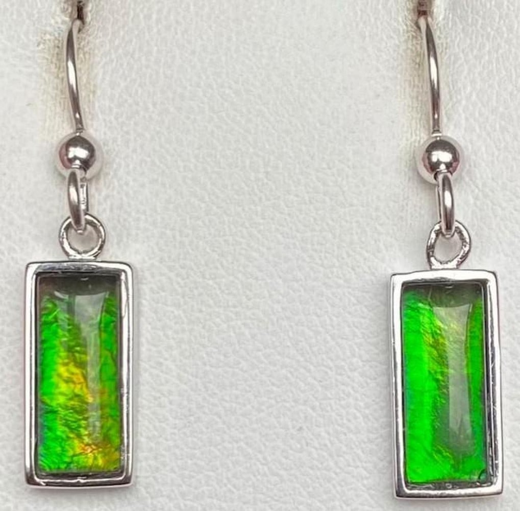 Ocean Crest Ammolite Earrings: Ocean Crest Ammolite Earrings Shimmering with hues of vibrant green and deep blue, the Ocean Crest Ammolite Earrings capture the ever-changing beauty of the sea. Set in a refined setting that enhances