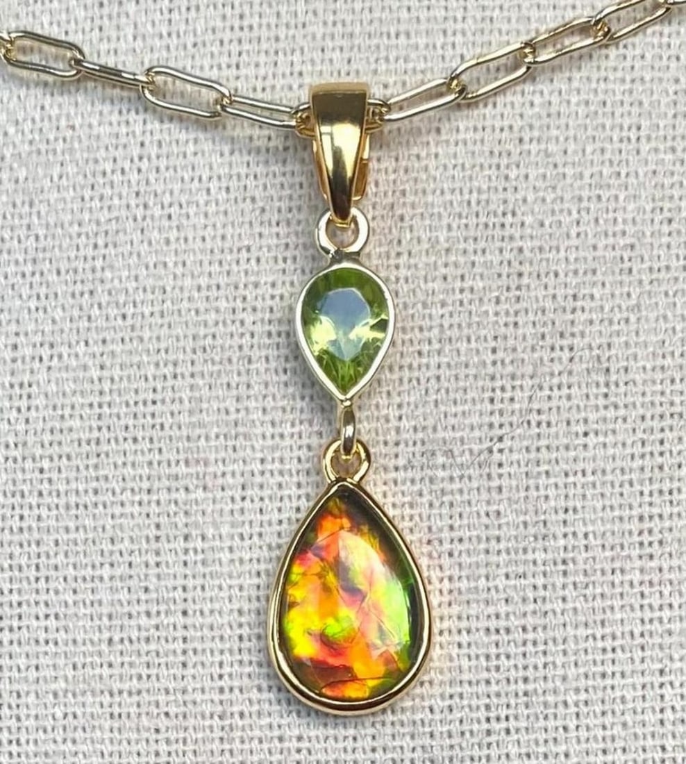 Teardrop Ammolite Pendant with Peridot Accent in 925 Gold Vermeil: Teardrop Ammolite Pendant with Peridot Accent in 925 Gold Vermeil This ammolite pendant features a gem with a vibrant autumn-colored pattern. It has a 12mm x 8mm low dome triplet set in a sterling sil
