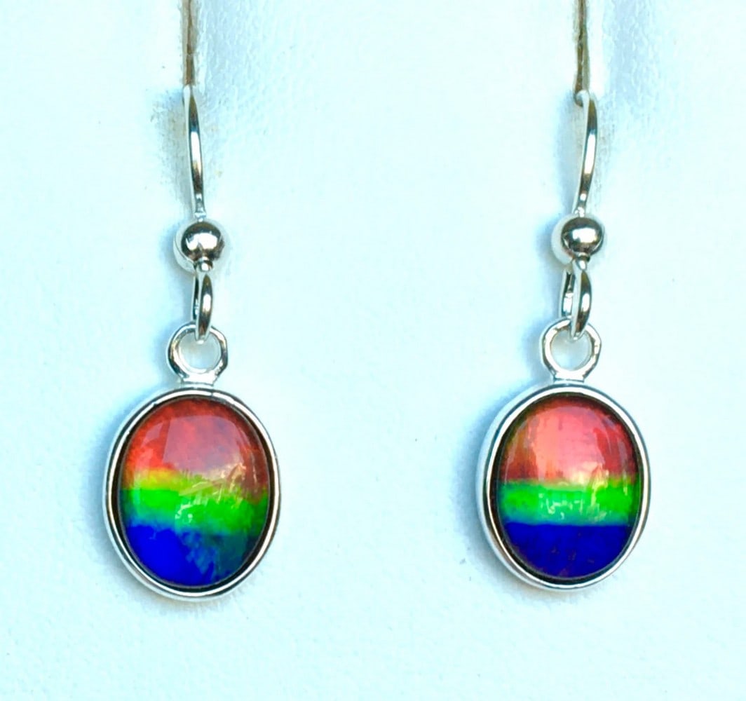 Multi-colour Ammolite Earrings: Multi-colour Ammolite Earrings These Ammolite earrings feature vibrant multicolored gemstones, each measuring 10mm x 8mm with a low-dome quartz cap. Set in sterling silver, they hang from matching