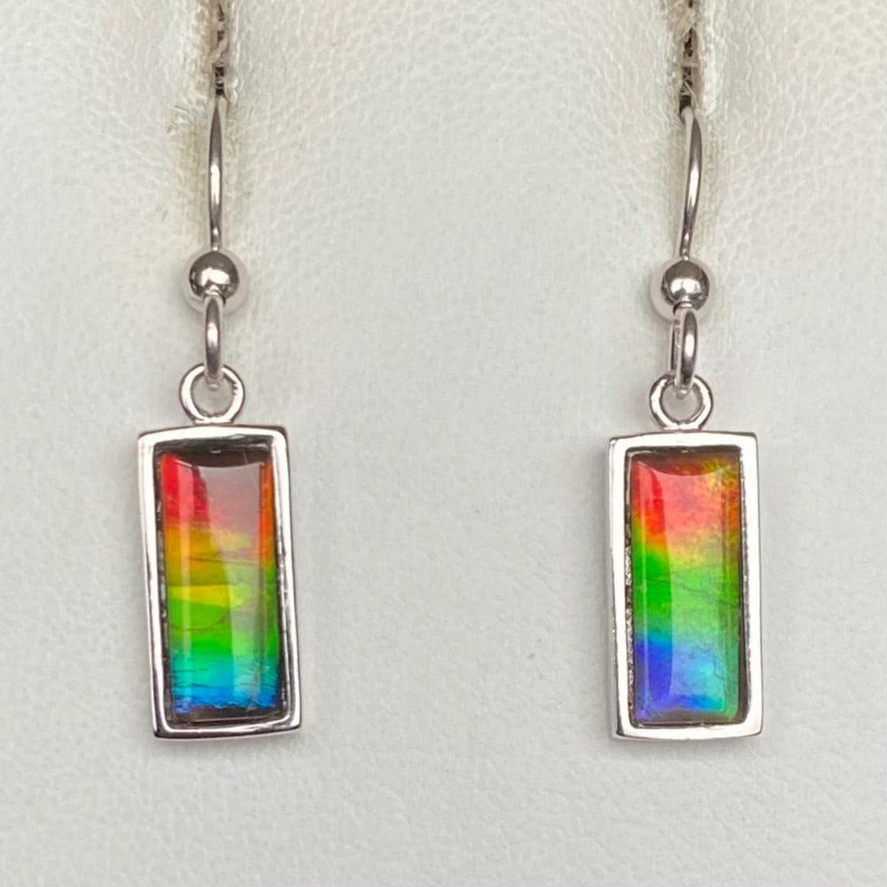 Multi-colour Ammolite Earrings: Multi-colour Ammolite Earrings These earrings feature 12mm x 5mm low-dome quartz-capped triplets, set in rhodium-plated sterling silver for a tarnish-resistant finish. Suspended from matching