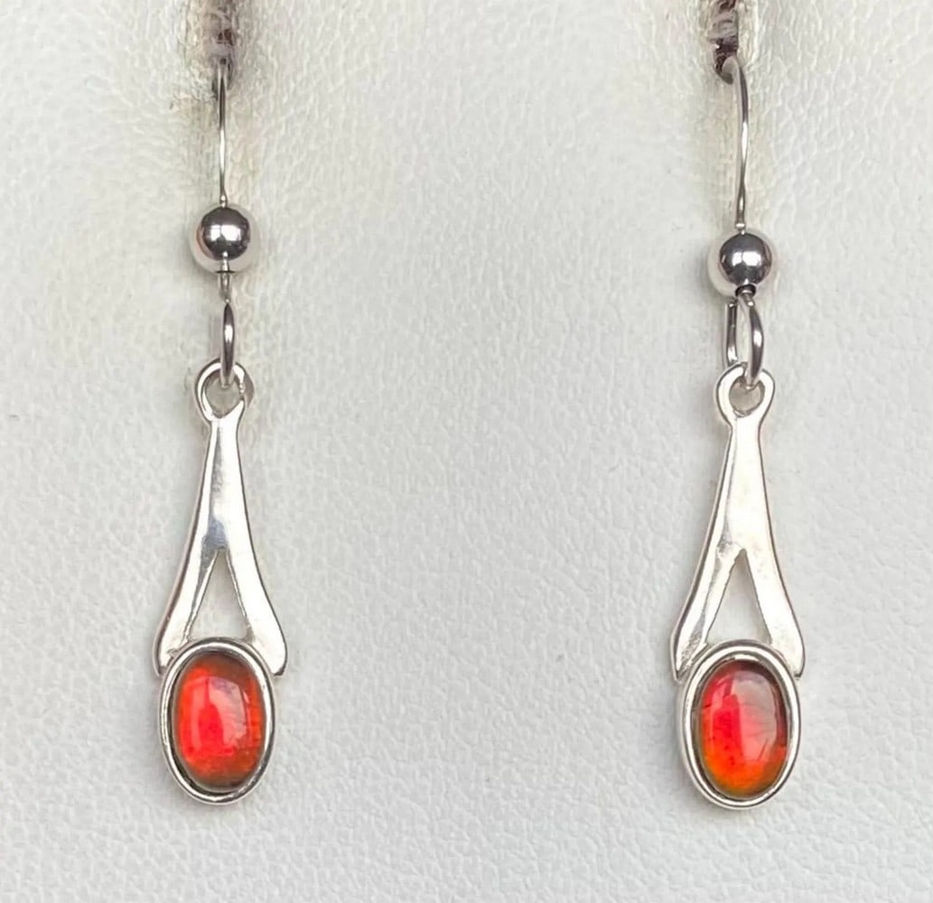 Petite Red Ammolite Earrings: Petite Red Ammolite Earrings This set of Ammolite earrings features petite red gemstones that shift to green at extreme angles. The 6mm x 4mm quartz-capped triplets are set in 925 sterling silver for